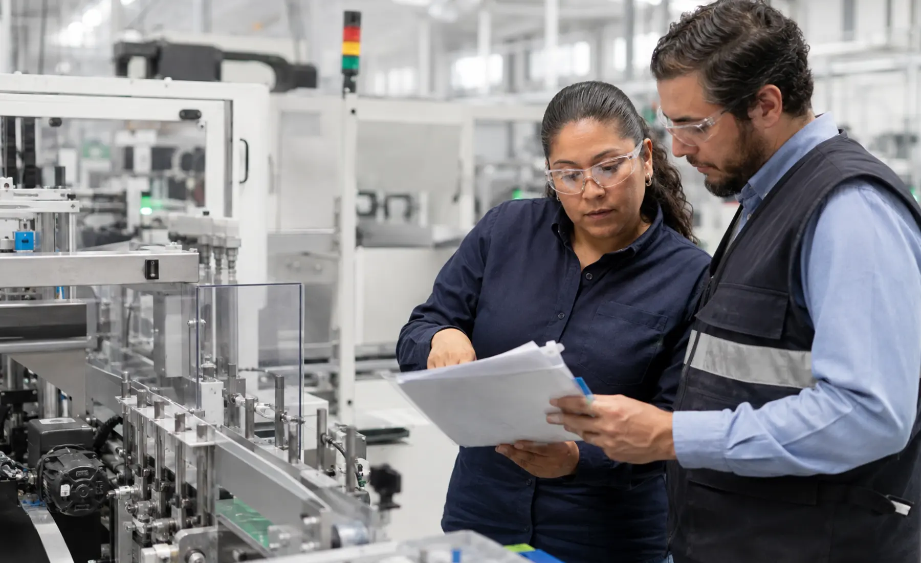 Quality manager and auditor reviewing production evidence in a manufacturing facility